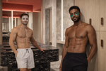 Two shirtless men standing in a modern indoor setting with marble walls and a counter wearing face pilates reformer face and under eye masks