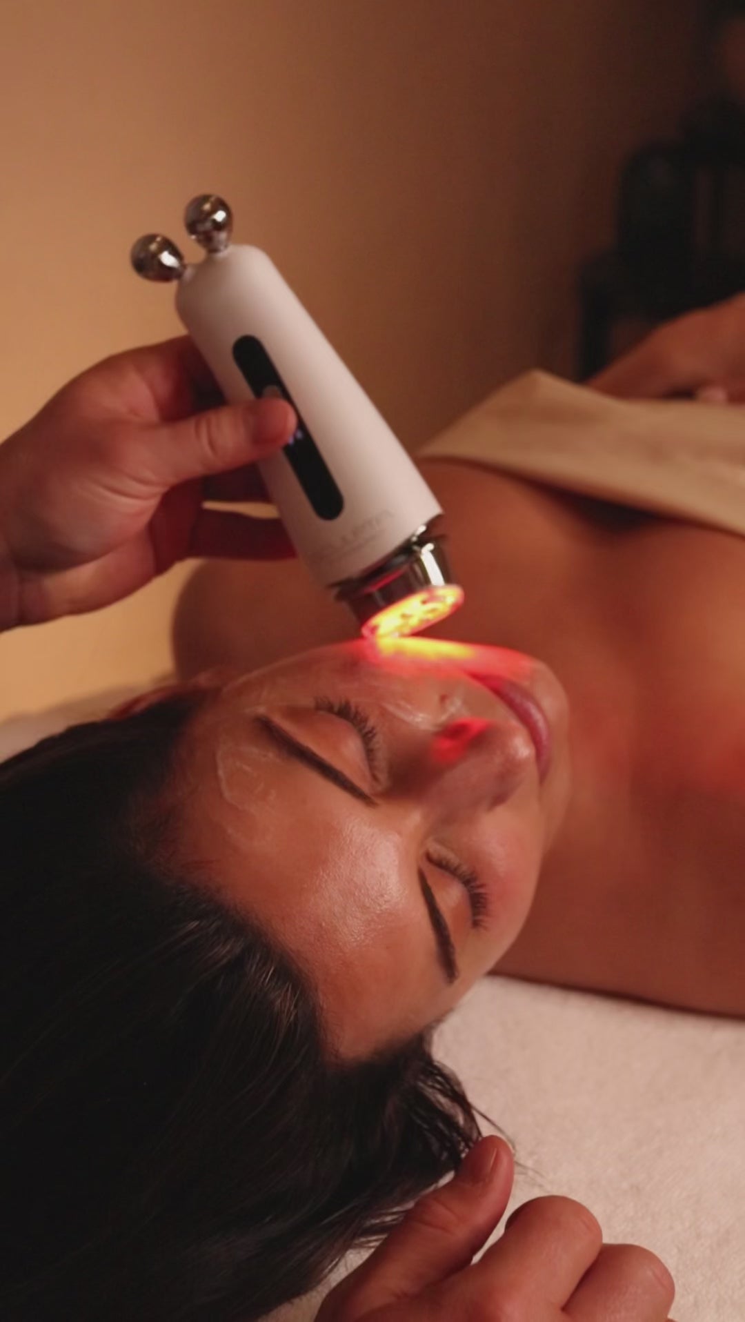 Face pilates video demonstrating contrast therapy with red led light on woman's face